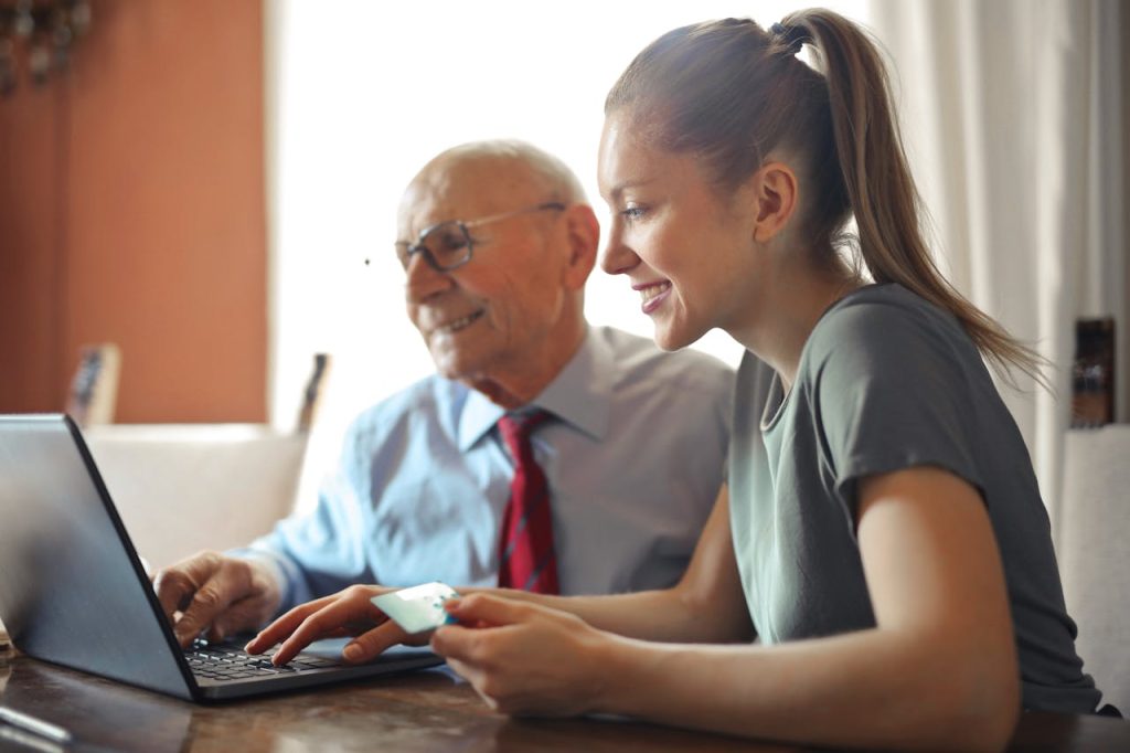 a woman and man looking at a laptop