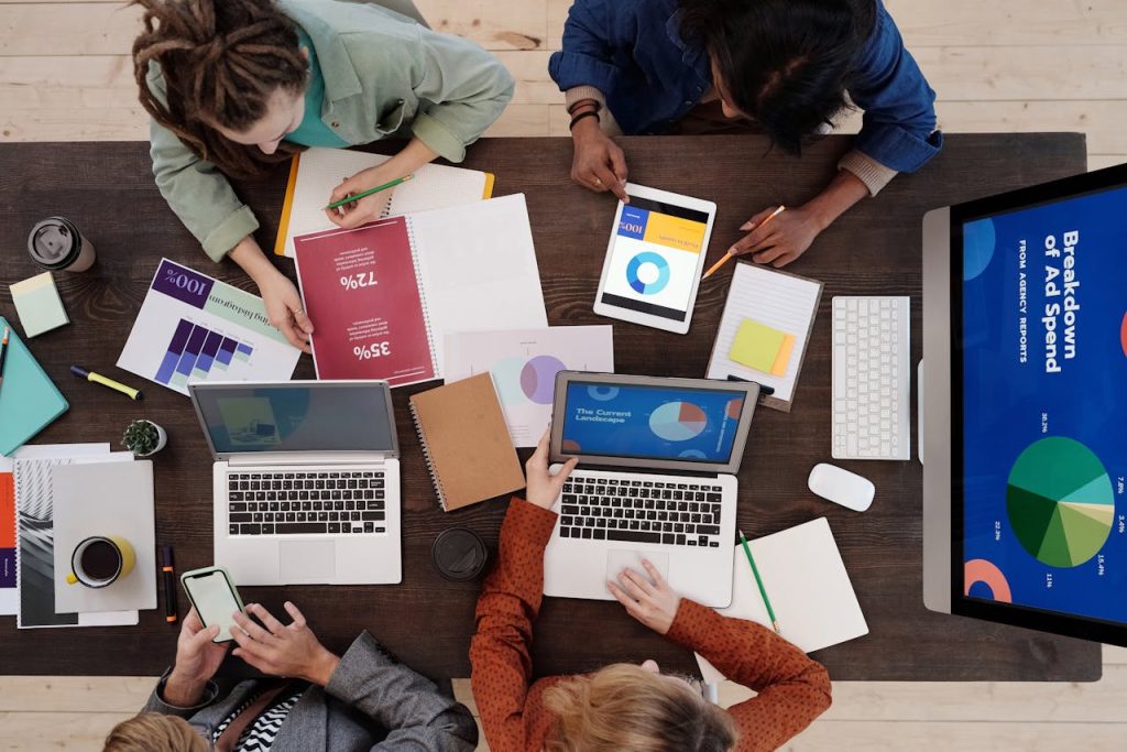 a group of people working on laptops and tablets